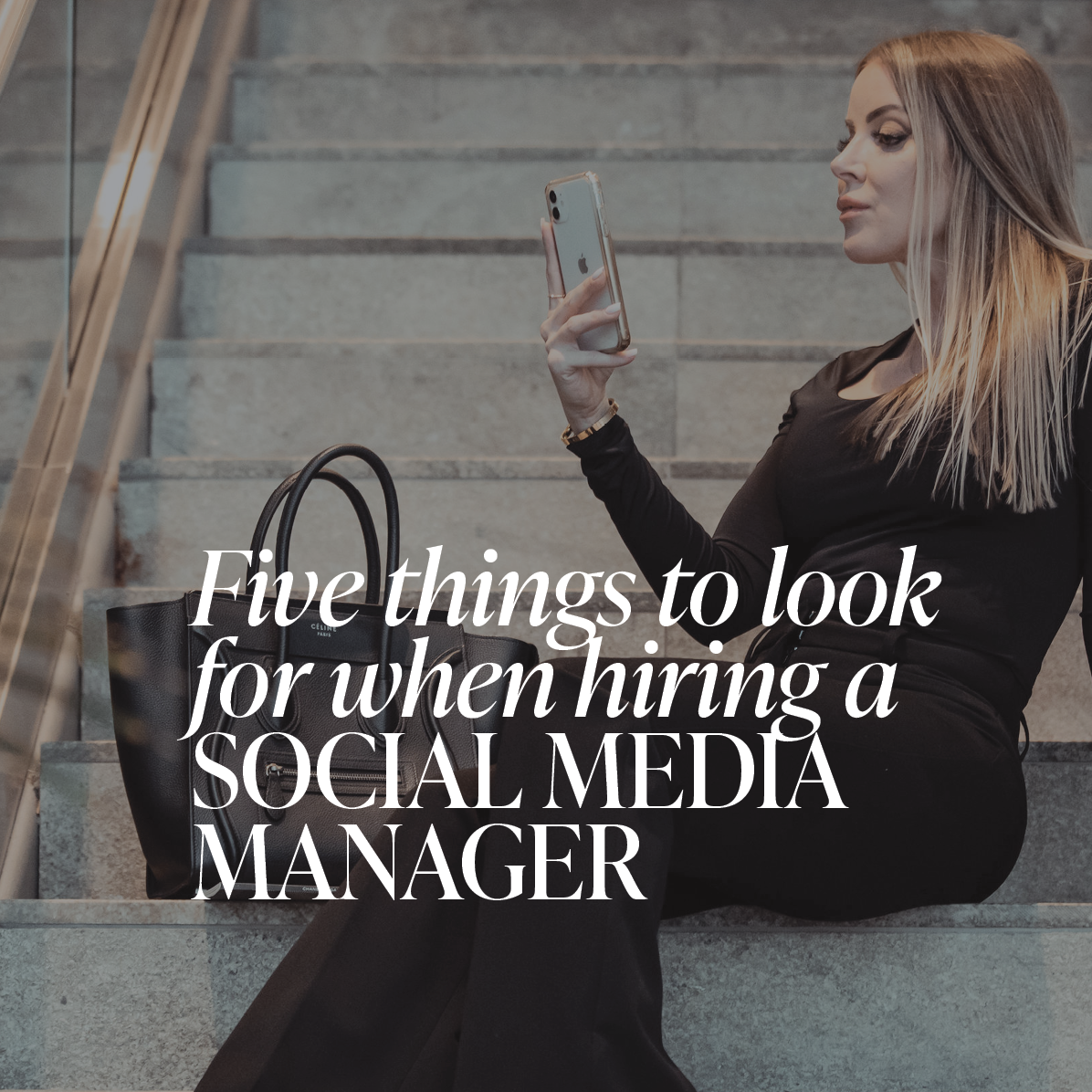 Woman sitting on a staircase looking at her phone with the text overlay "Five things to look for when hiring a social media manager'