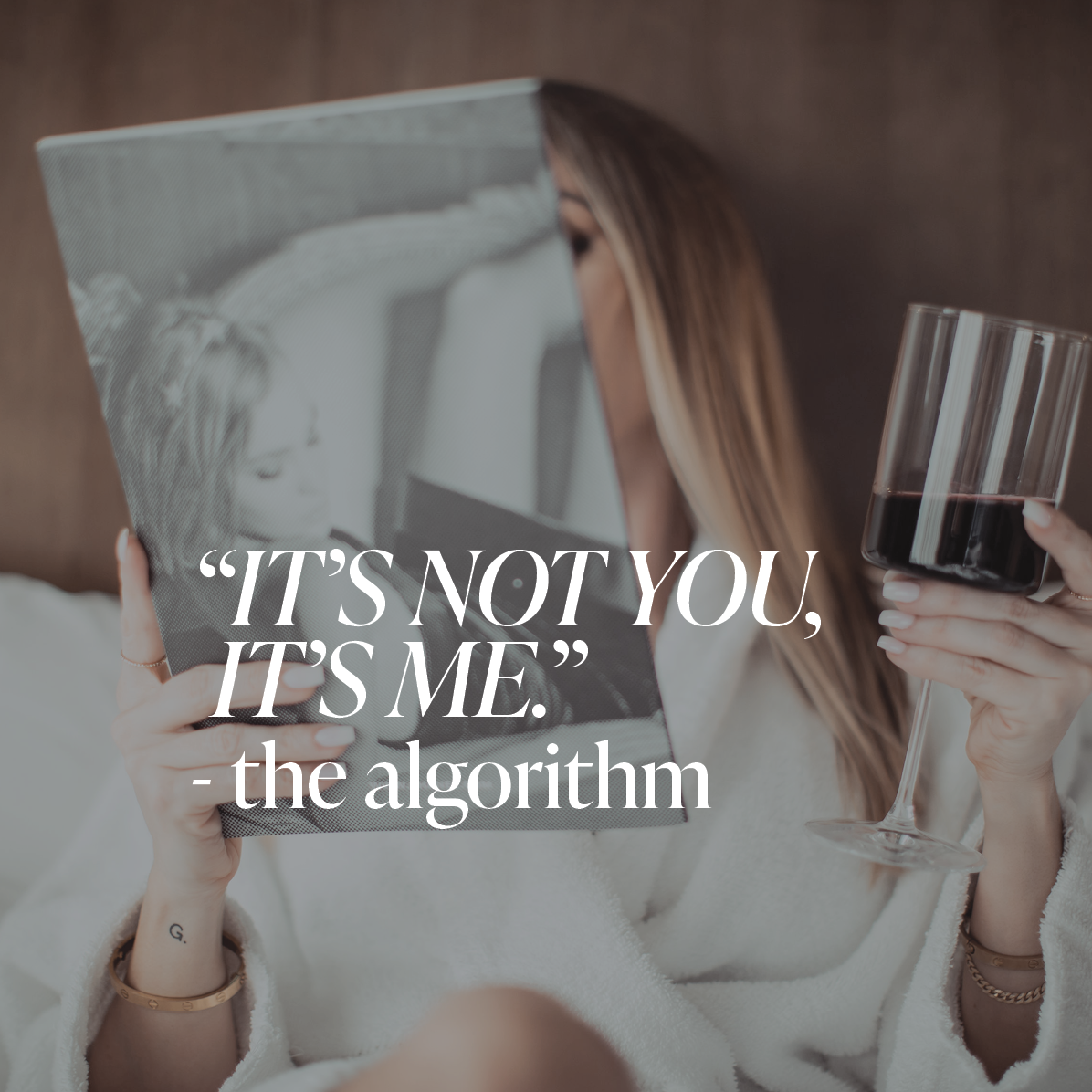Woman sitting in bed with a bathroom, glass of red wine, reading a magazine with white text overlay that reads "It's not you, it's me. -The Algorithm"